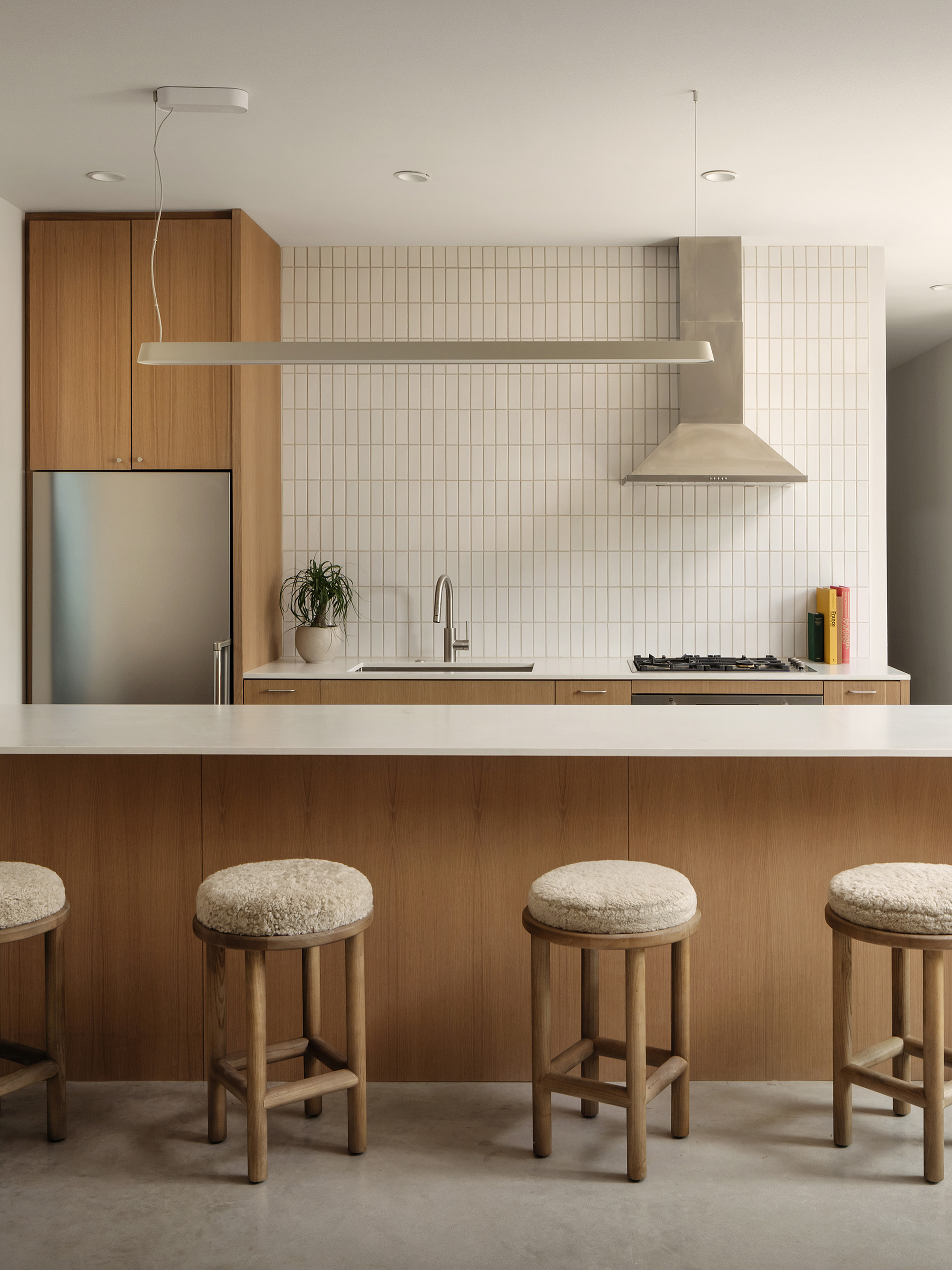 Kitchen with white tile, wood island and bench seating